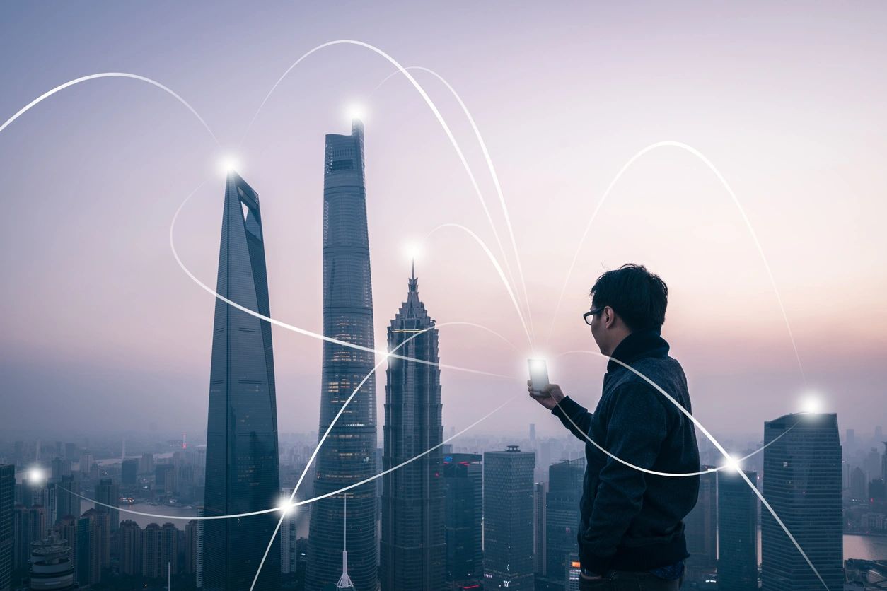 Man with smartphone overlooking futuristic cityscape.